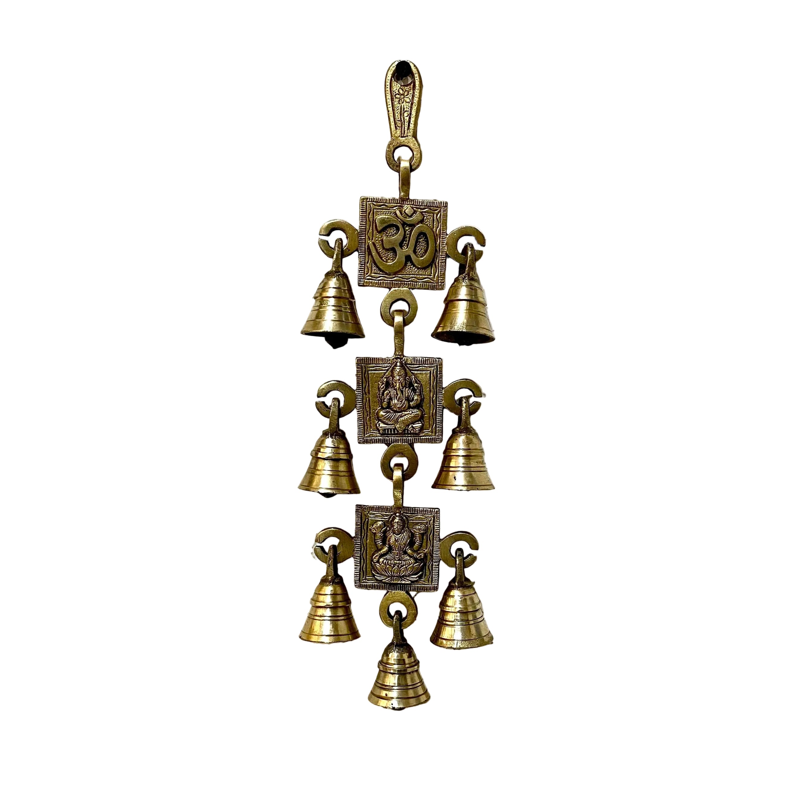 Decorative brass bell hanging on a textured white wall.