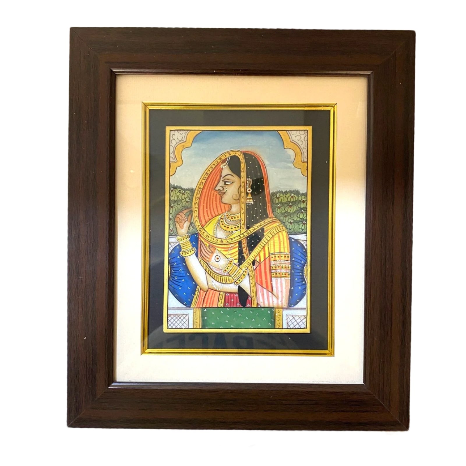 Framed artwork of a traditional portrait with a woman in ornate clothing on a textured wall.