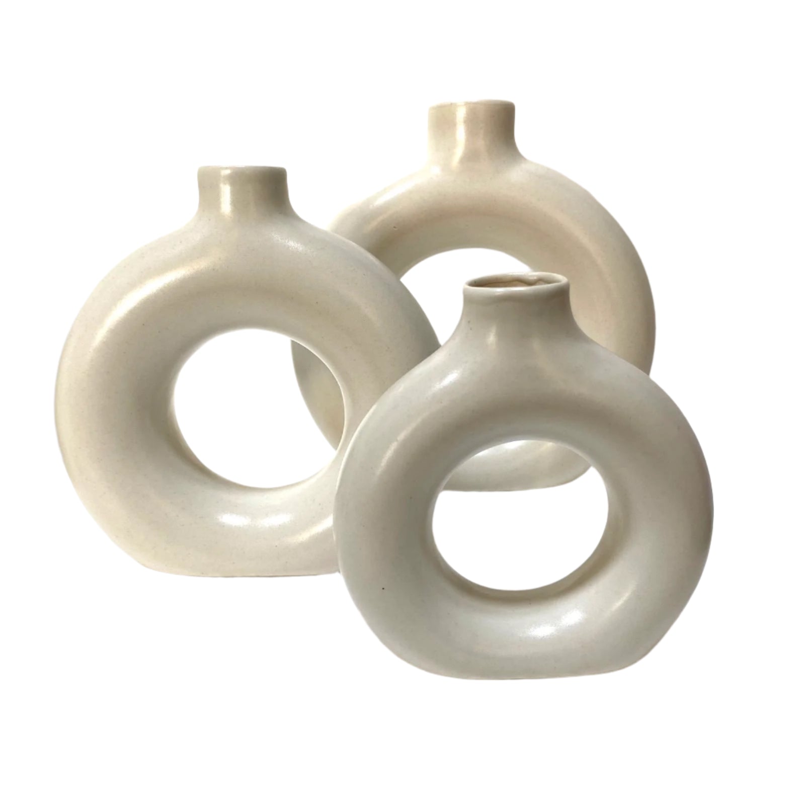 Three white ceramic vases with circular designs on a white surface.