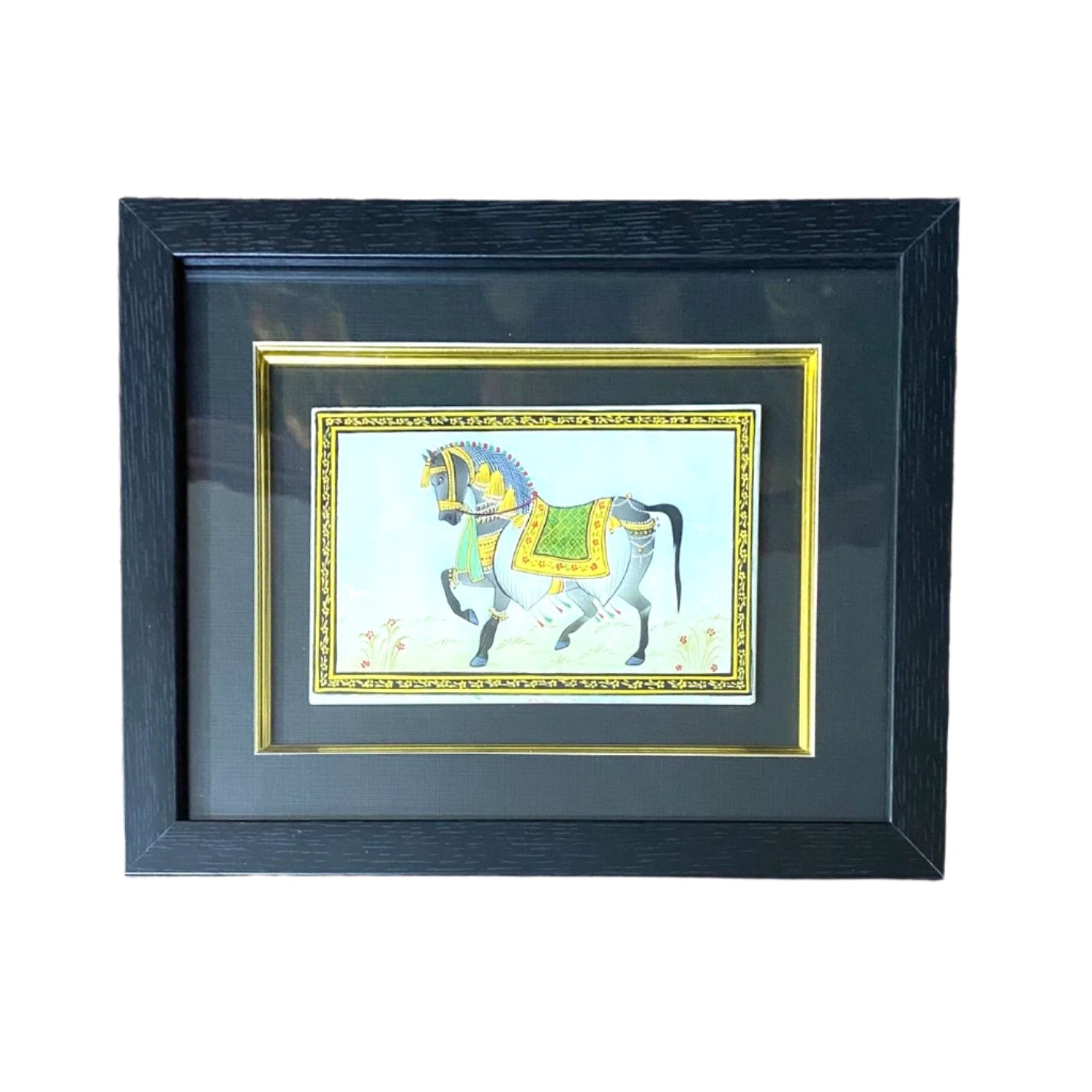 Framed artwork of a horse with a green saddle on a purple patterned wall.