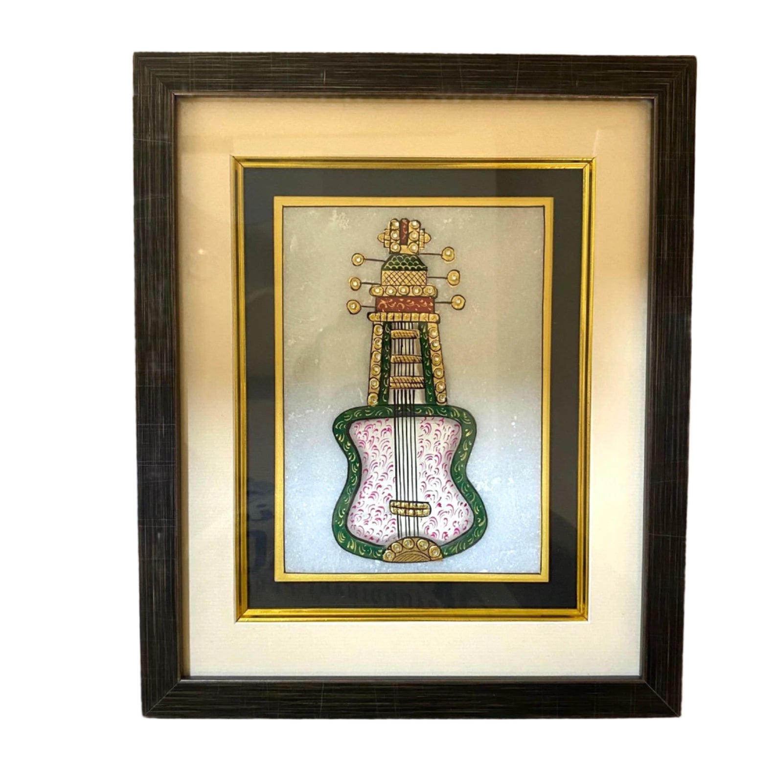 Framed artwork of a decorative guitar on a textured wall.