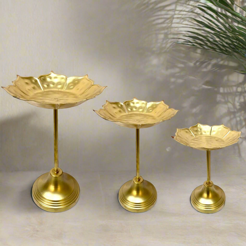 Three gold-colored decorative stands on a white background