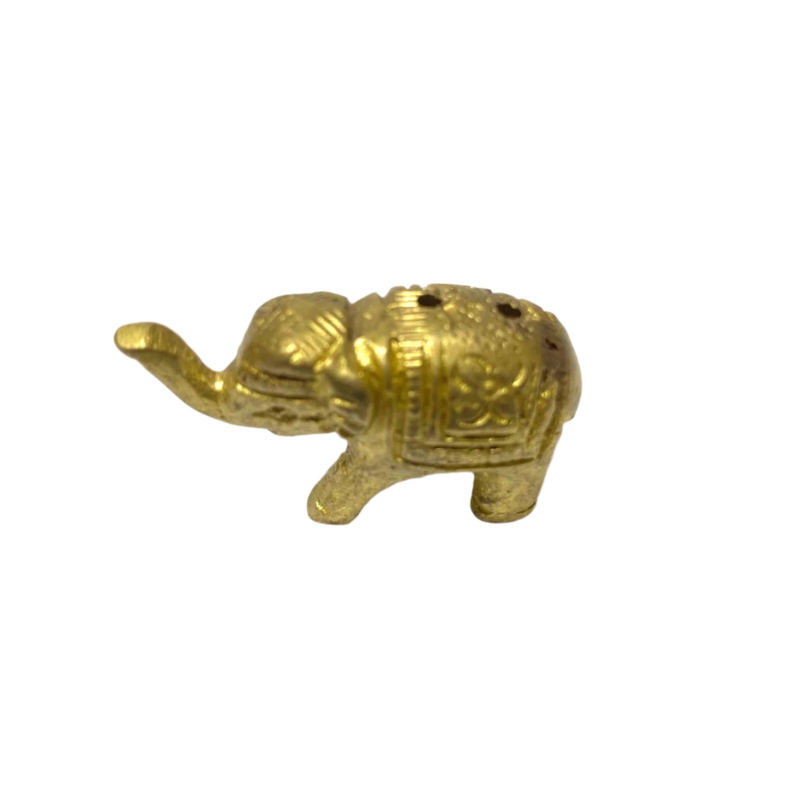 Small brass elephant figurine on a textured white surface