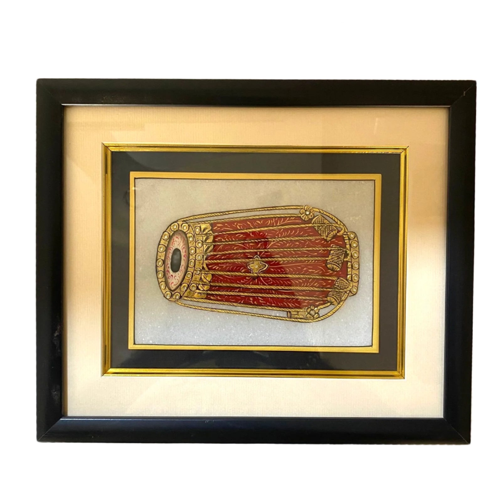 Framed decorative object with gold and red design on a beige background