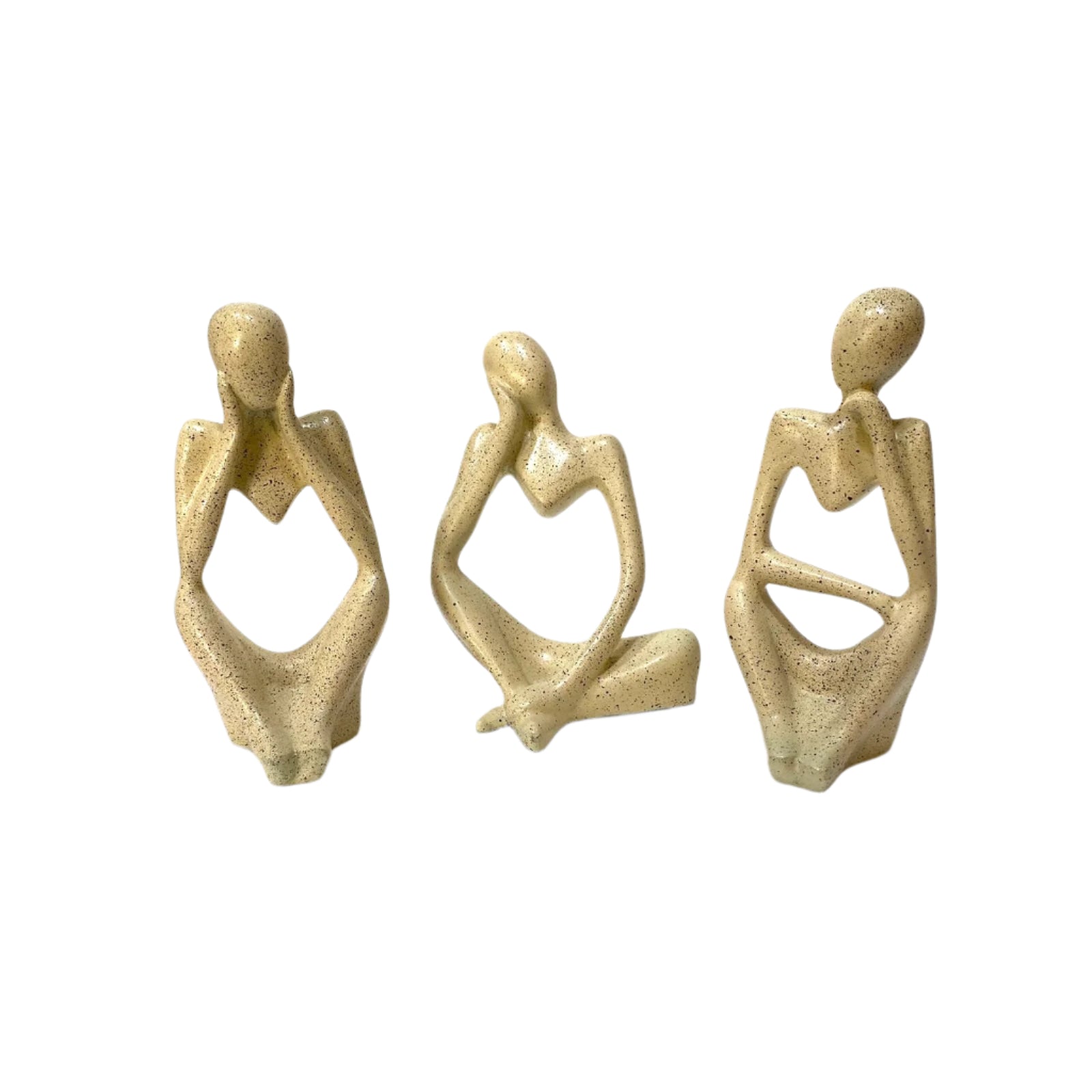 Three beige ceramic sculptures of sitting figures on a white surface.