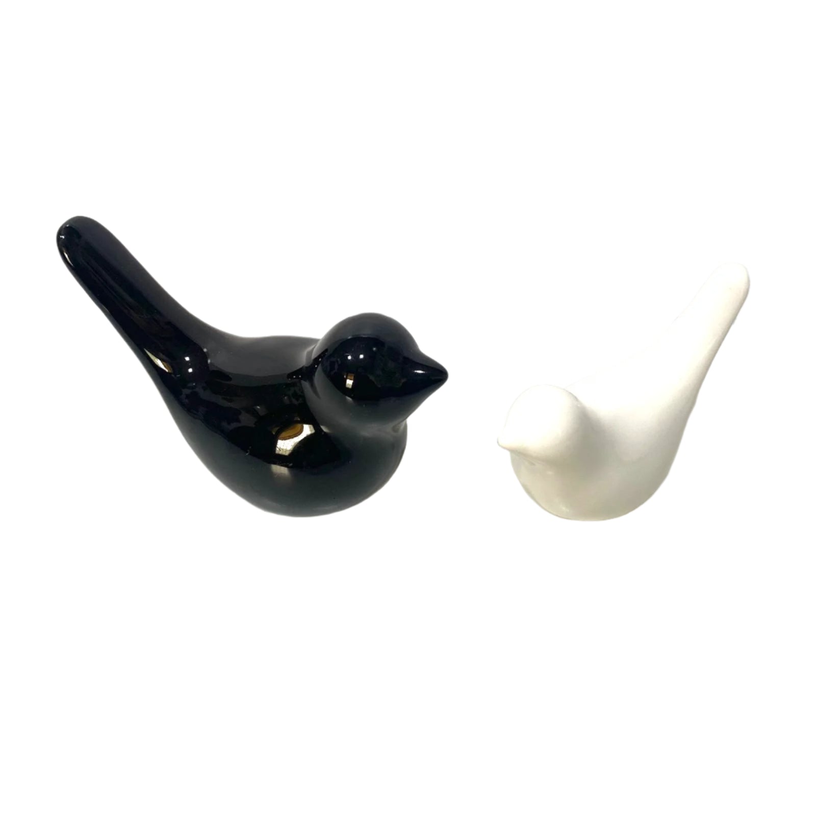 Black and white ceramic bird figurines on a white surface with a light gray background