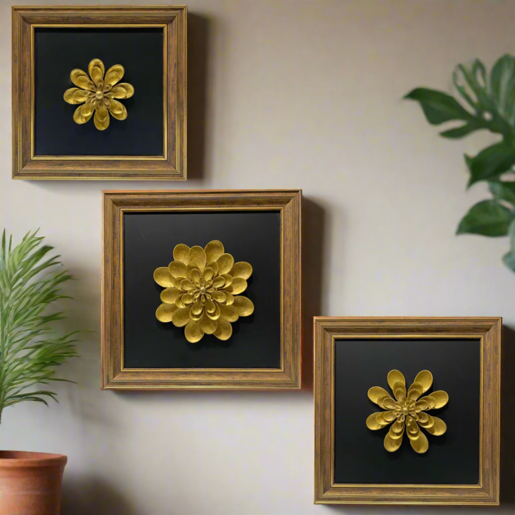 Three framed wall art pieces with gold floral designs on black backgrounds.