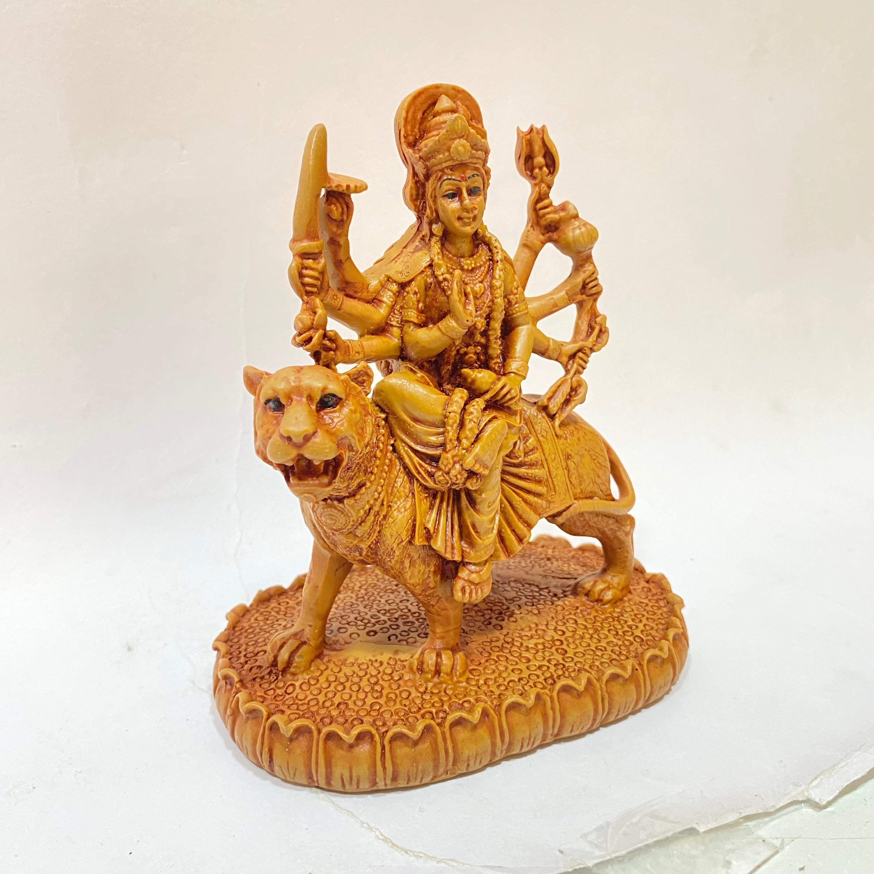 Statue of a deity riding a lion on a white background