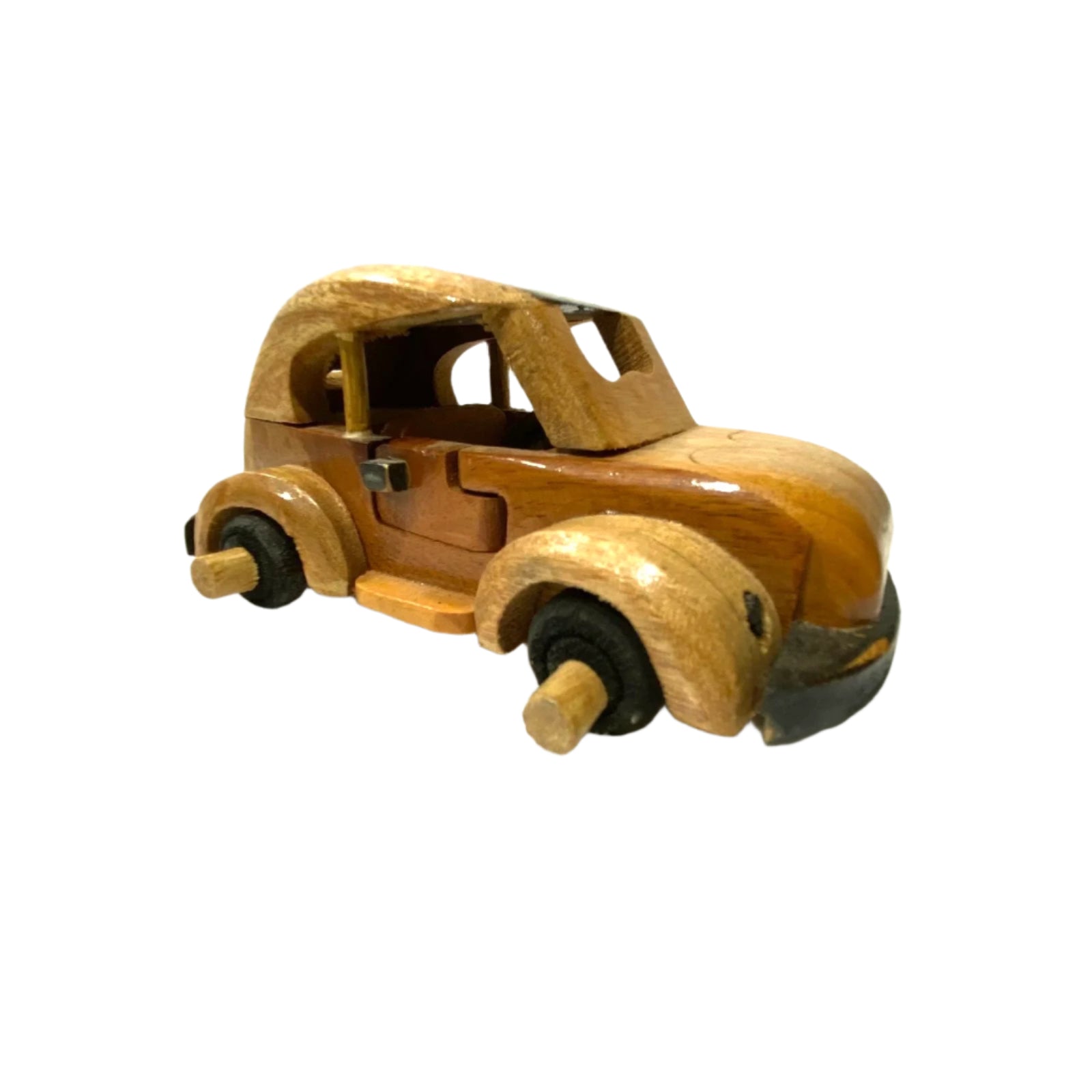 Wooden toy car on a white surface with a textured white wall background
