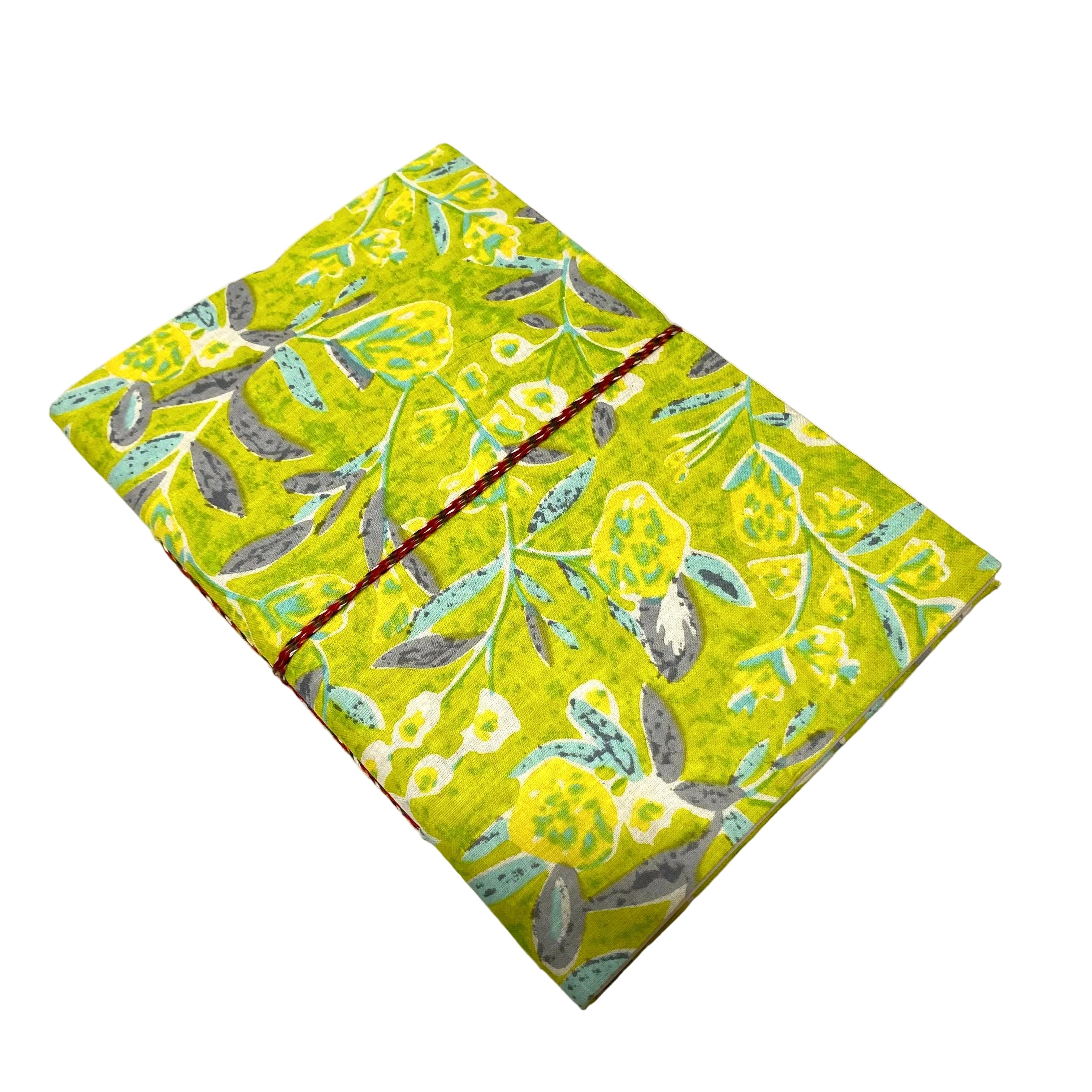 Green notebook with floral pattern on a white surface