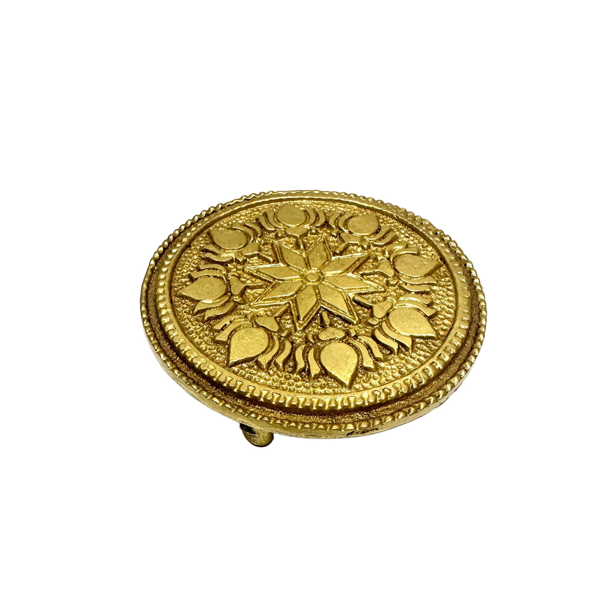 Decorative gold circular object on a white surface