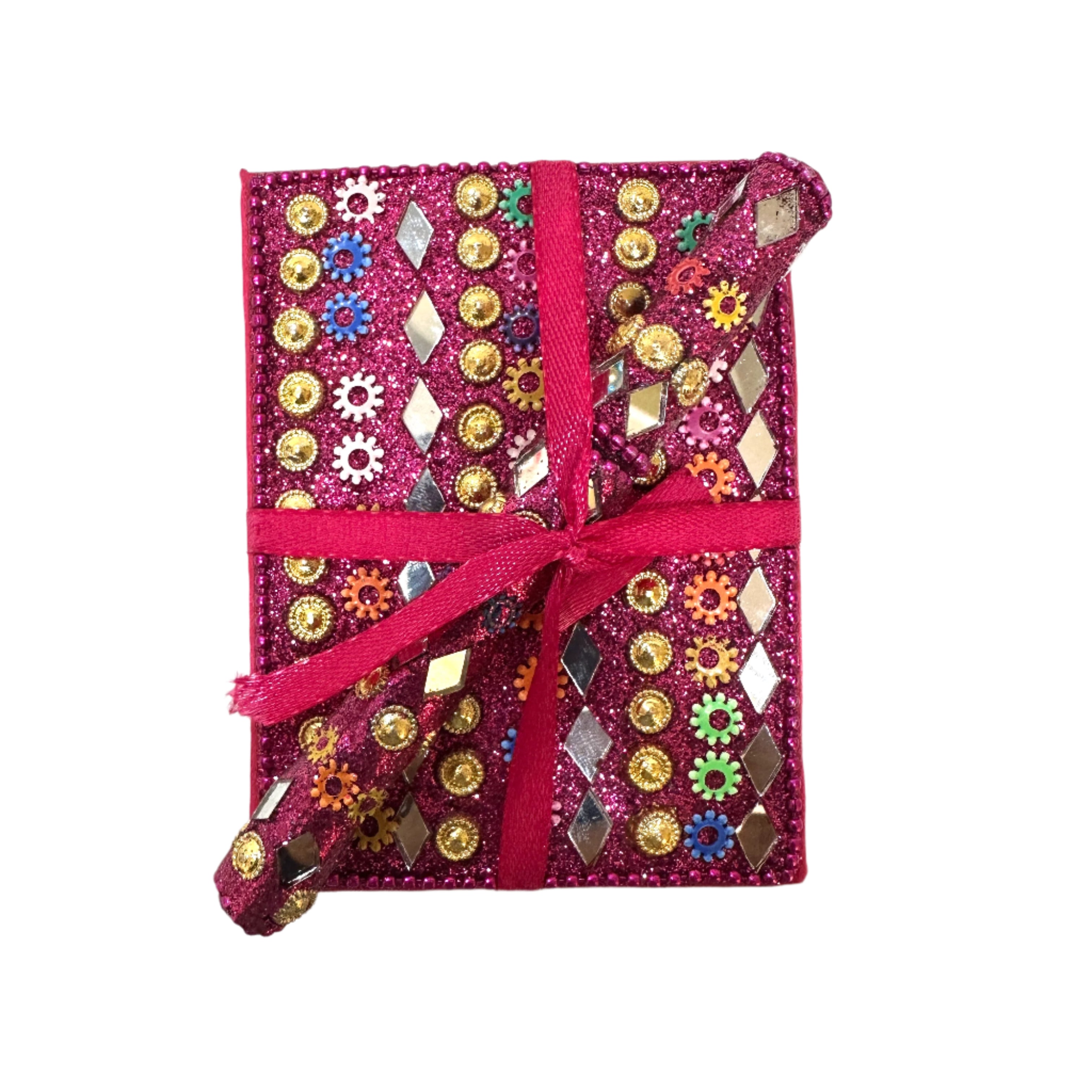 Decorative notebook with colorful embellishments and a pink ribbon on a textured white background