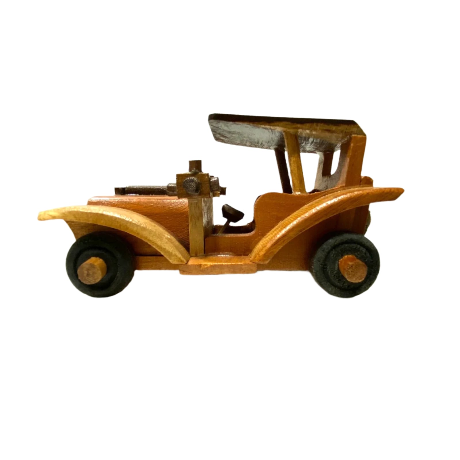 Wooden toy car on a white surface with a textured wall background