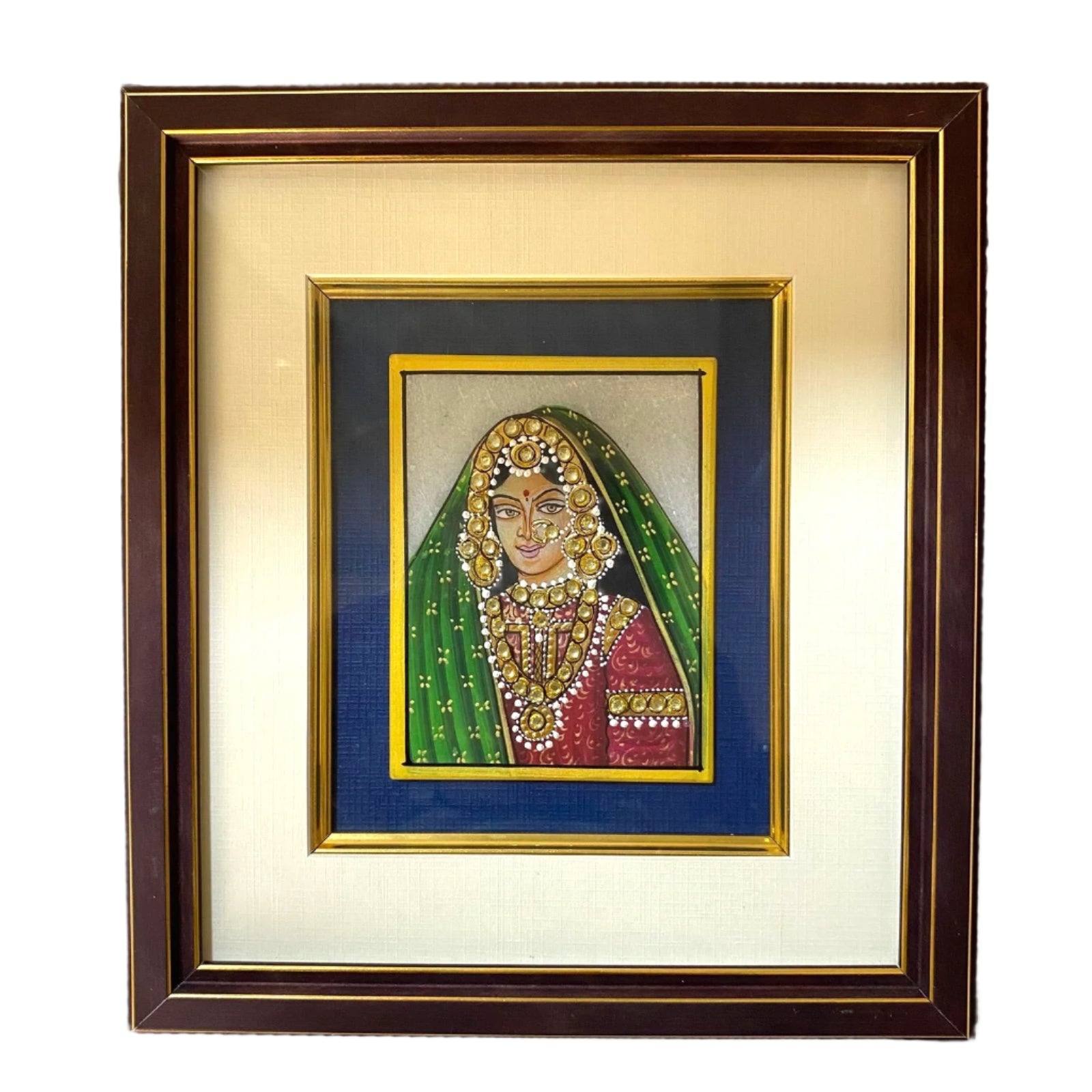 Framed artwork of a traditional portrait with jewelry and green headscarf on a textured wall.
