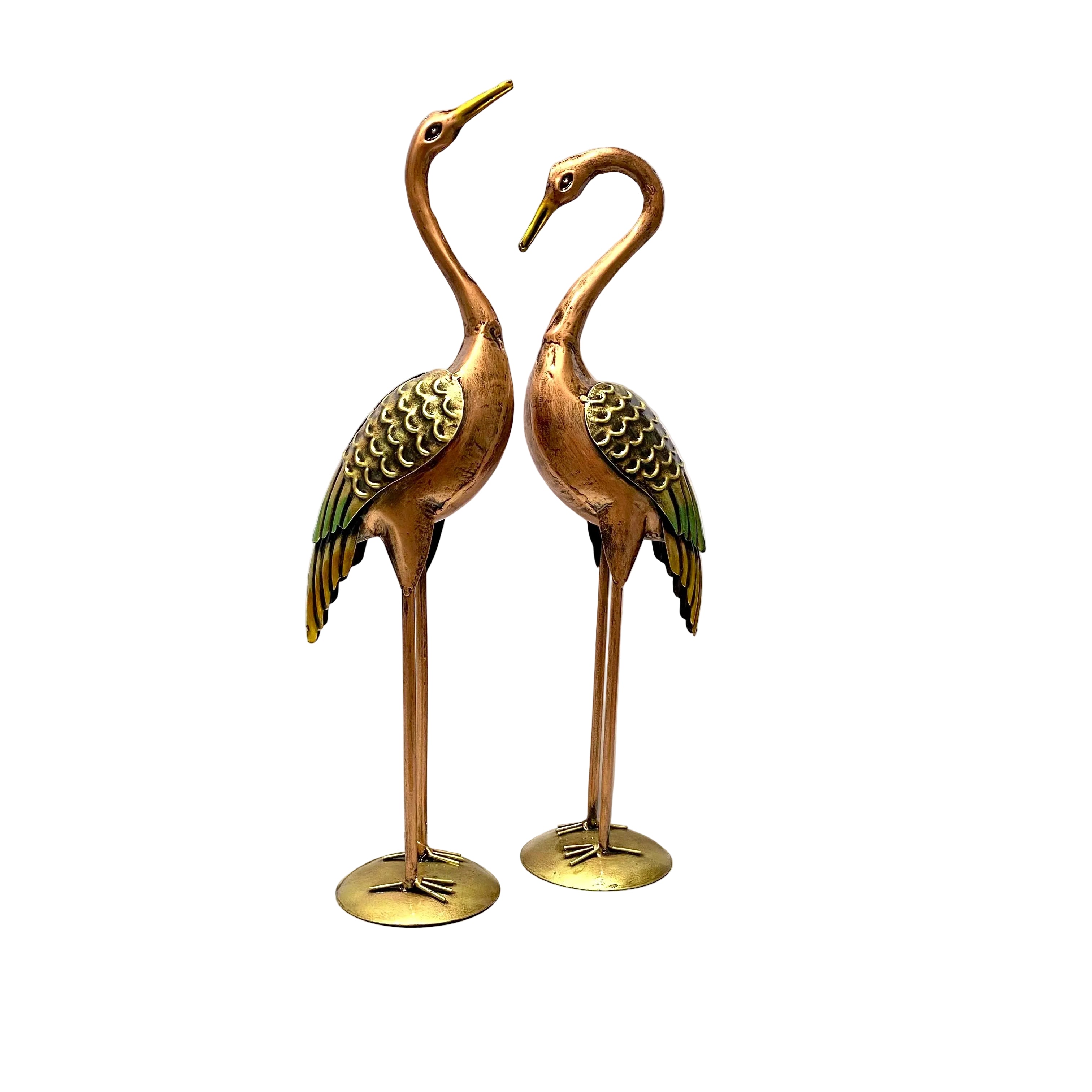 Two brass cranes on a white surface with a blurred background