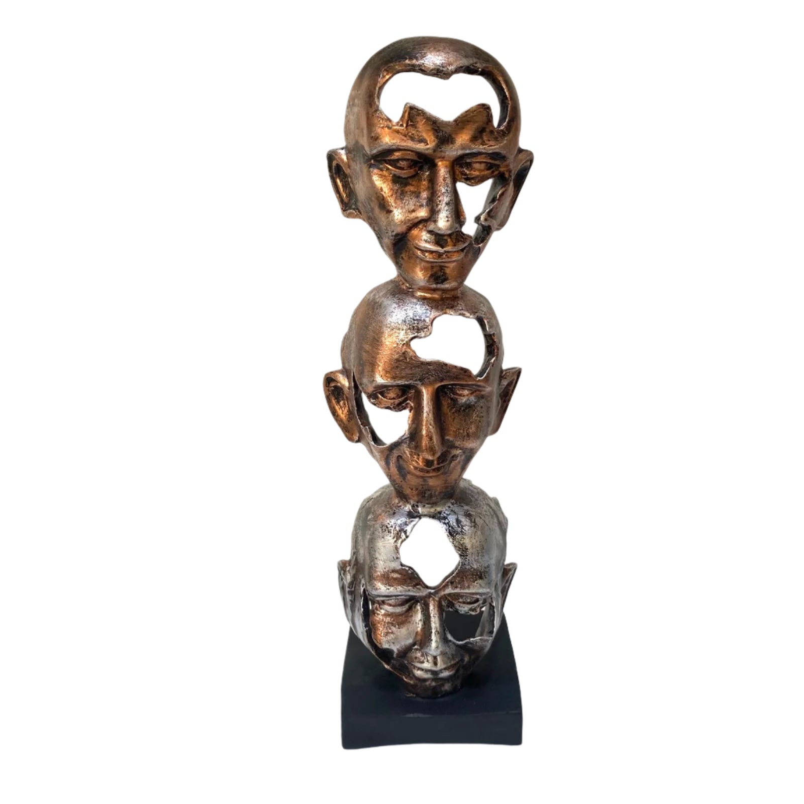 Bronze sculpture of three stacked faces on a white surface with a light gray background