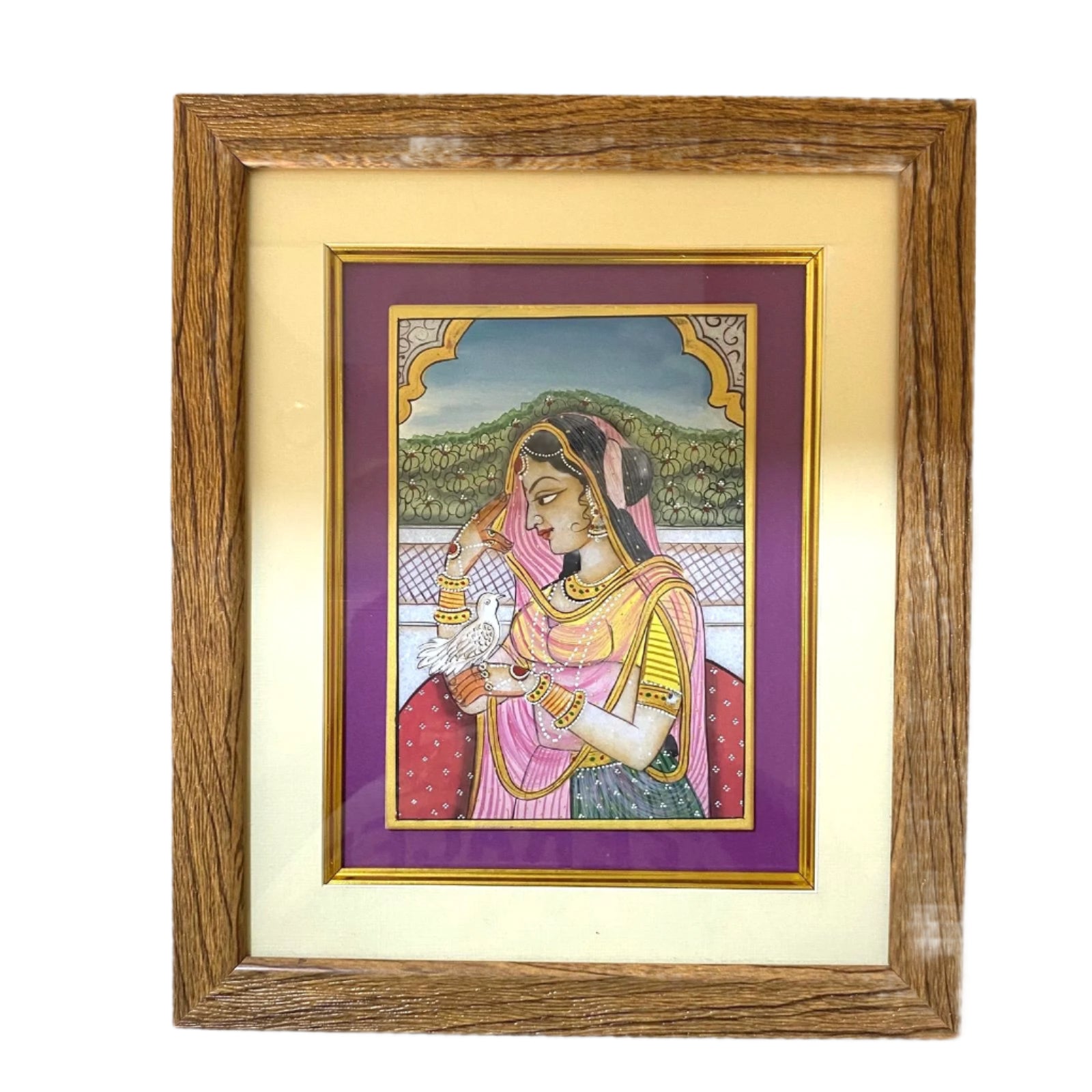 Framed artwork of a woman in traditional attire on a white wall.