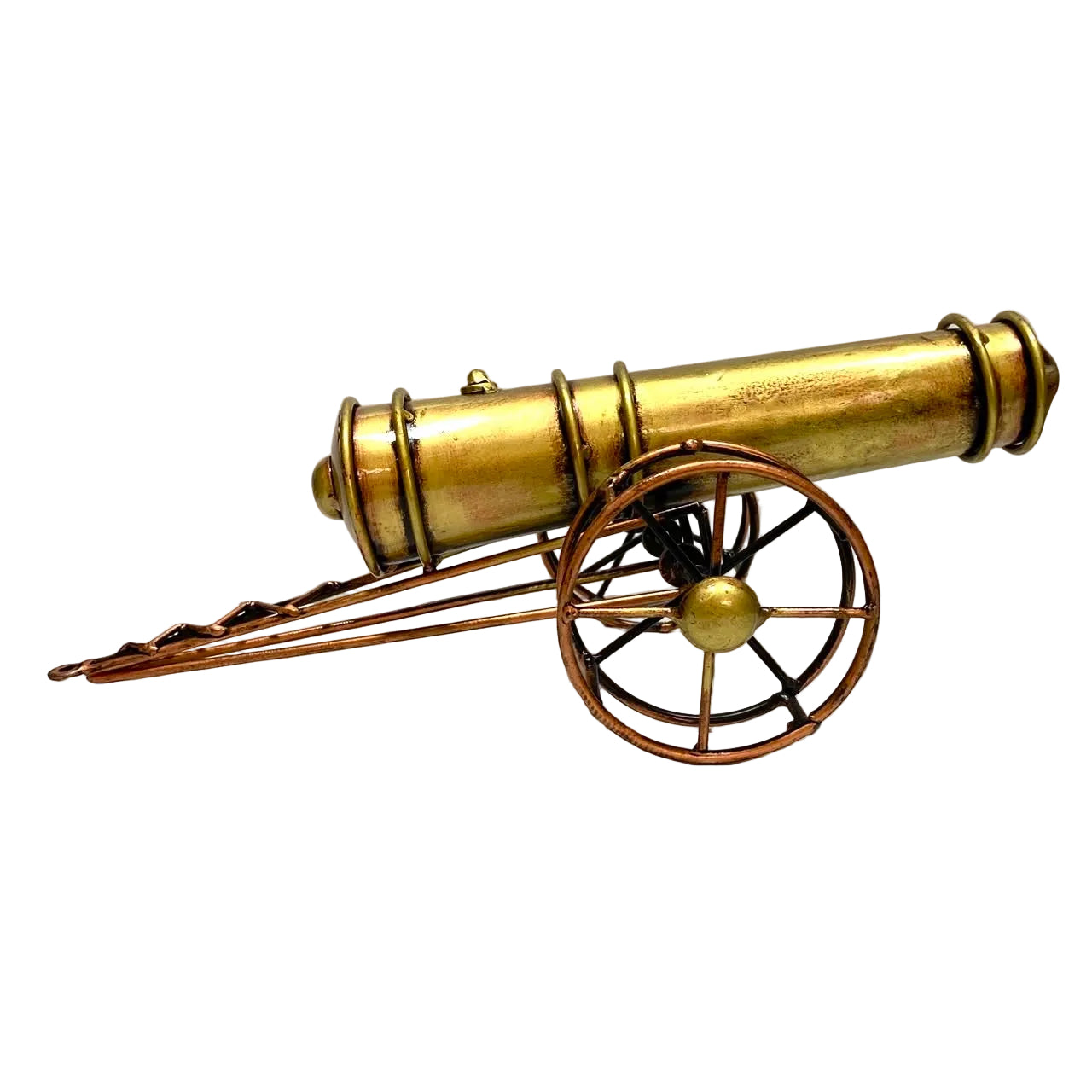 A miniature decorative cannon model with a brass-colored barrel and copper-toned wheels, displayed on a white surface against a white wall.