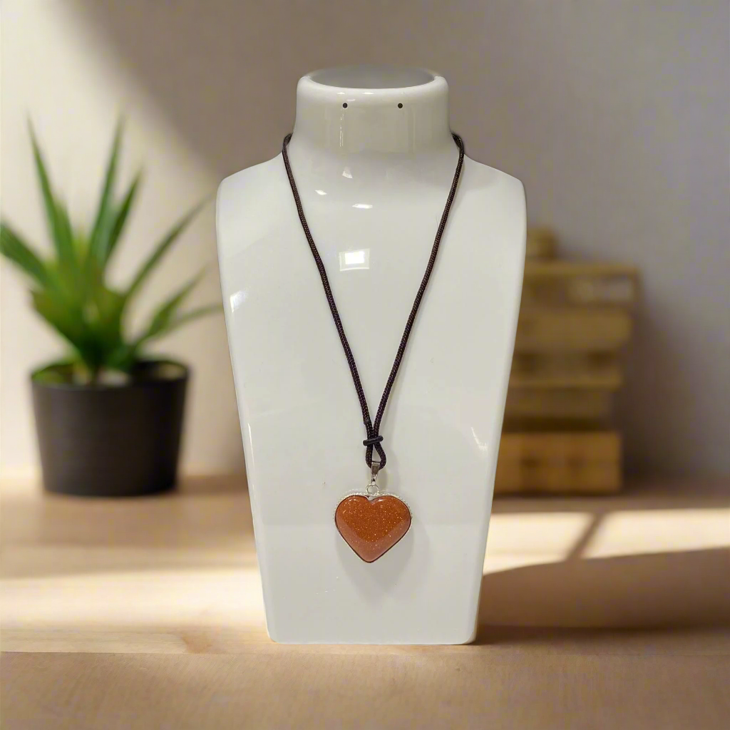Necklace with a heart-shaped pendant on a white mannequin bust against a black background