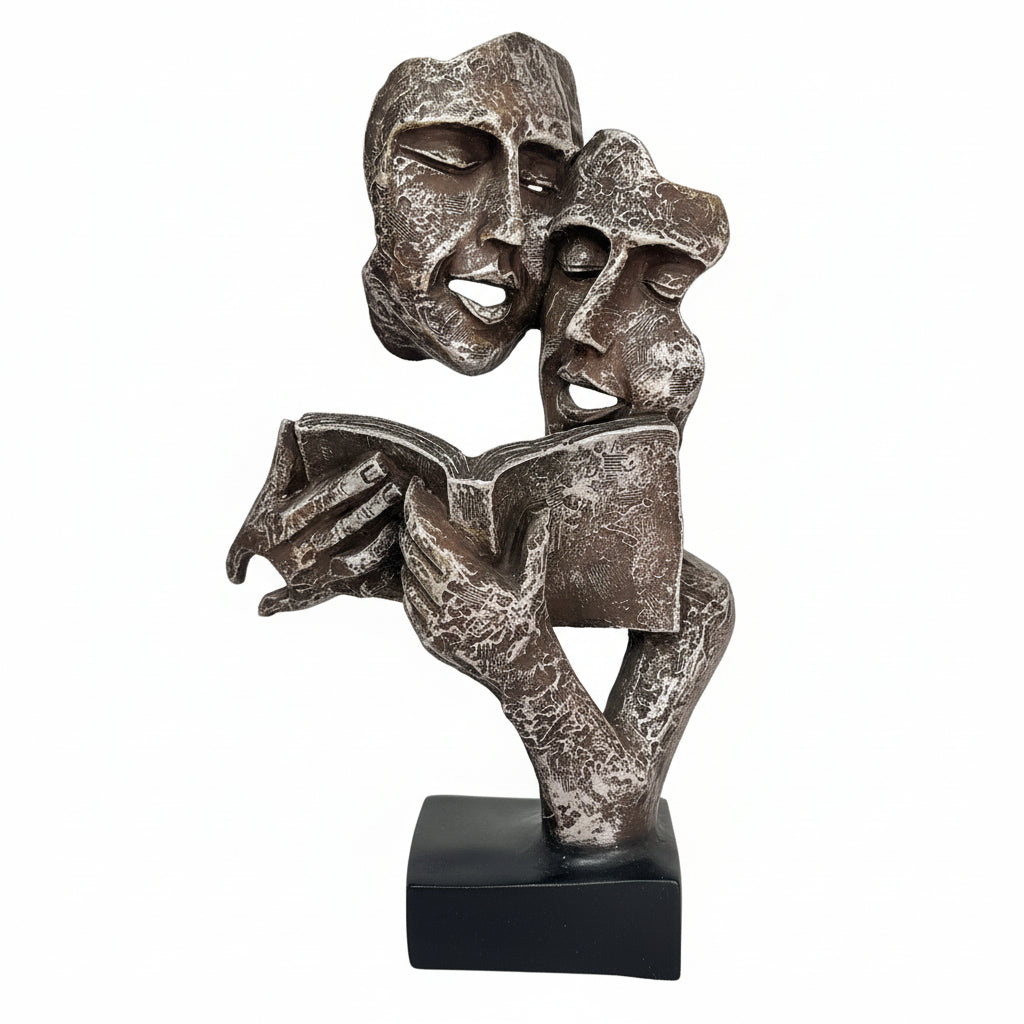 Bronze sculpture of two abstract figures on a dark surface with a blurred background