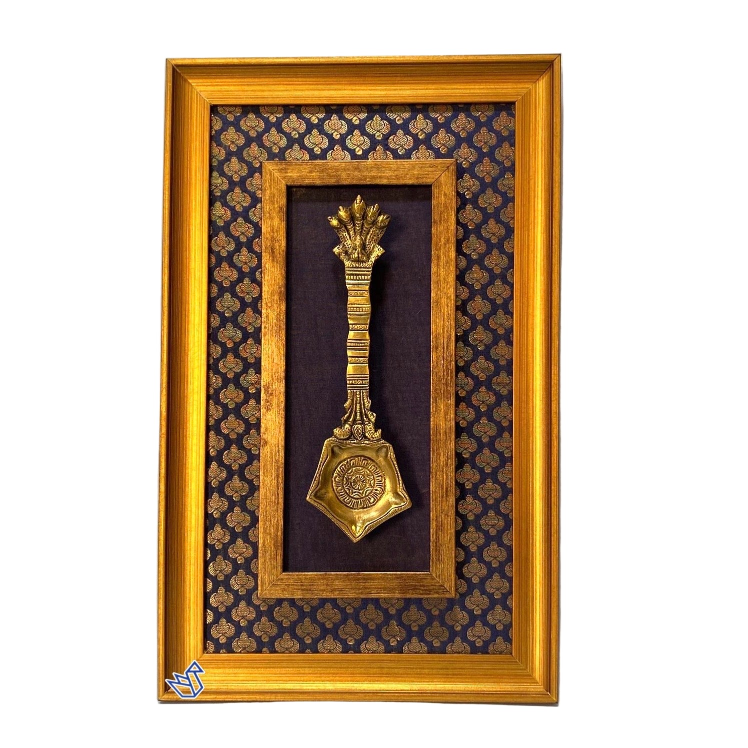 Decorative gold spoon in a wooden frame with a patterned background