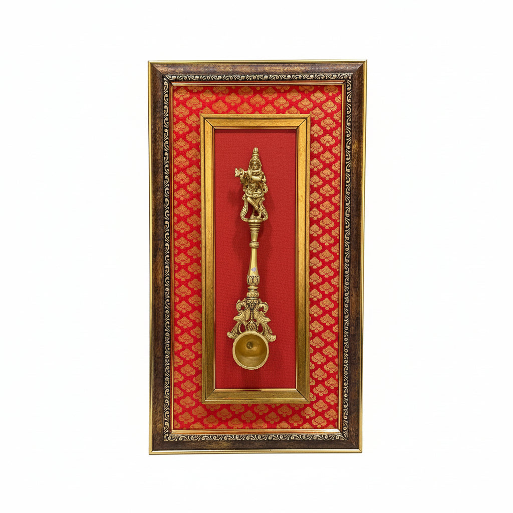 Decorative gold spoon in a frame with red patterned background