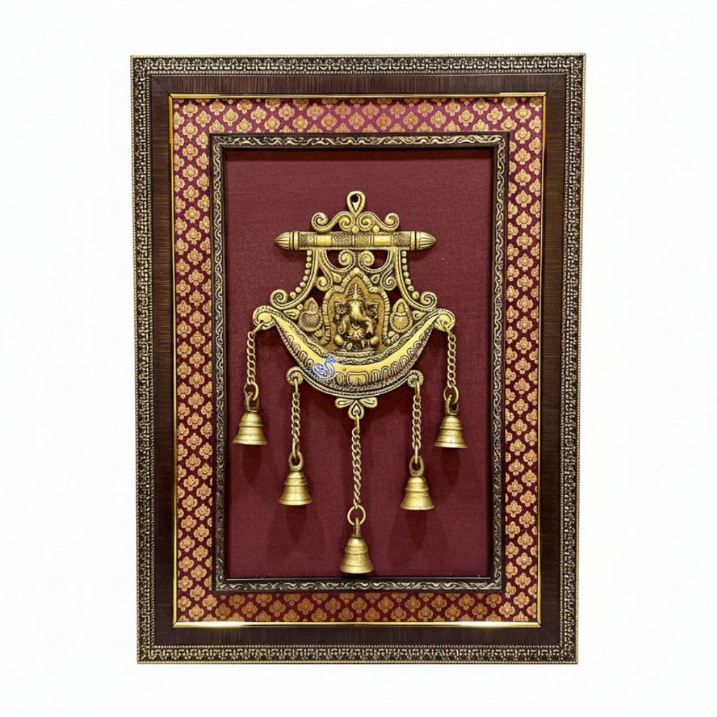 Decorative wall hanging with gold bells and intricate design in a brown frame.