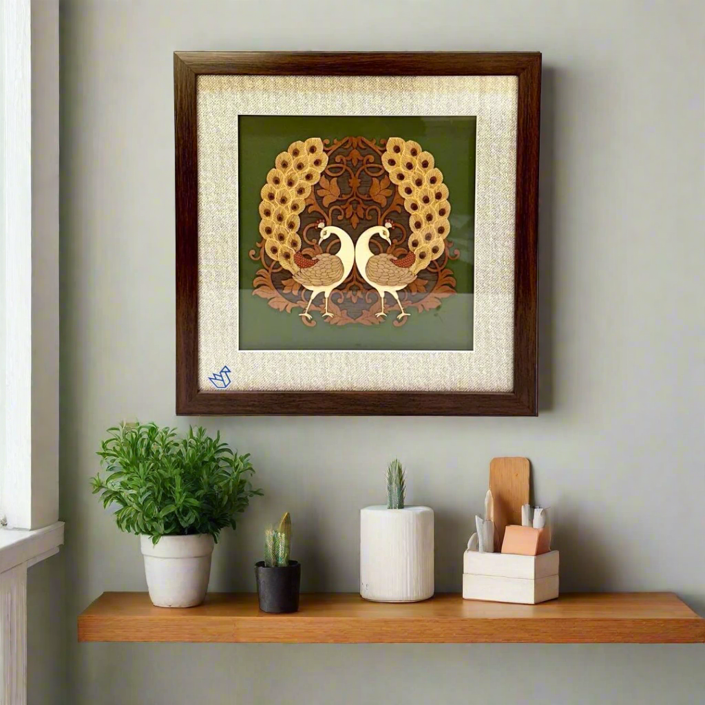 Framed artwork of two peacocks with a wreath on a green background