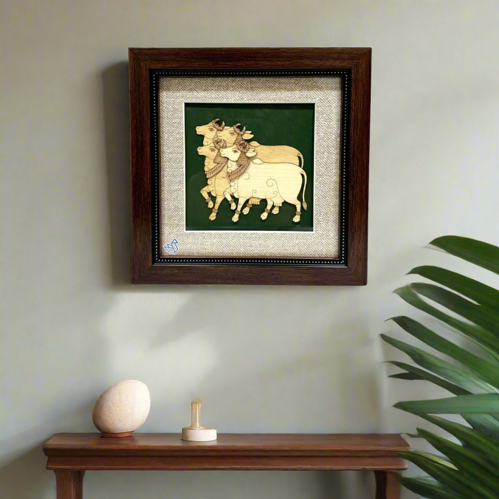 Framed artwork of two cows on a green background with a wooden frame.