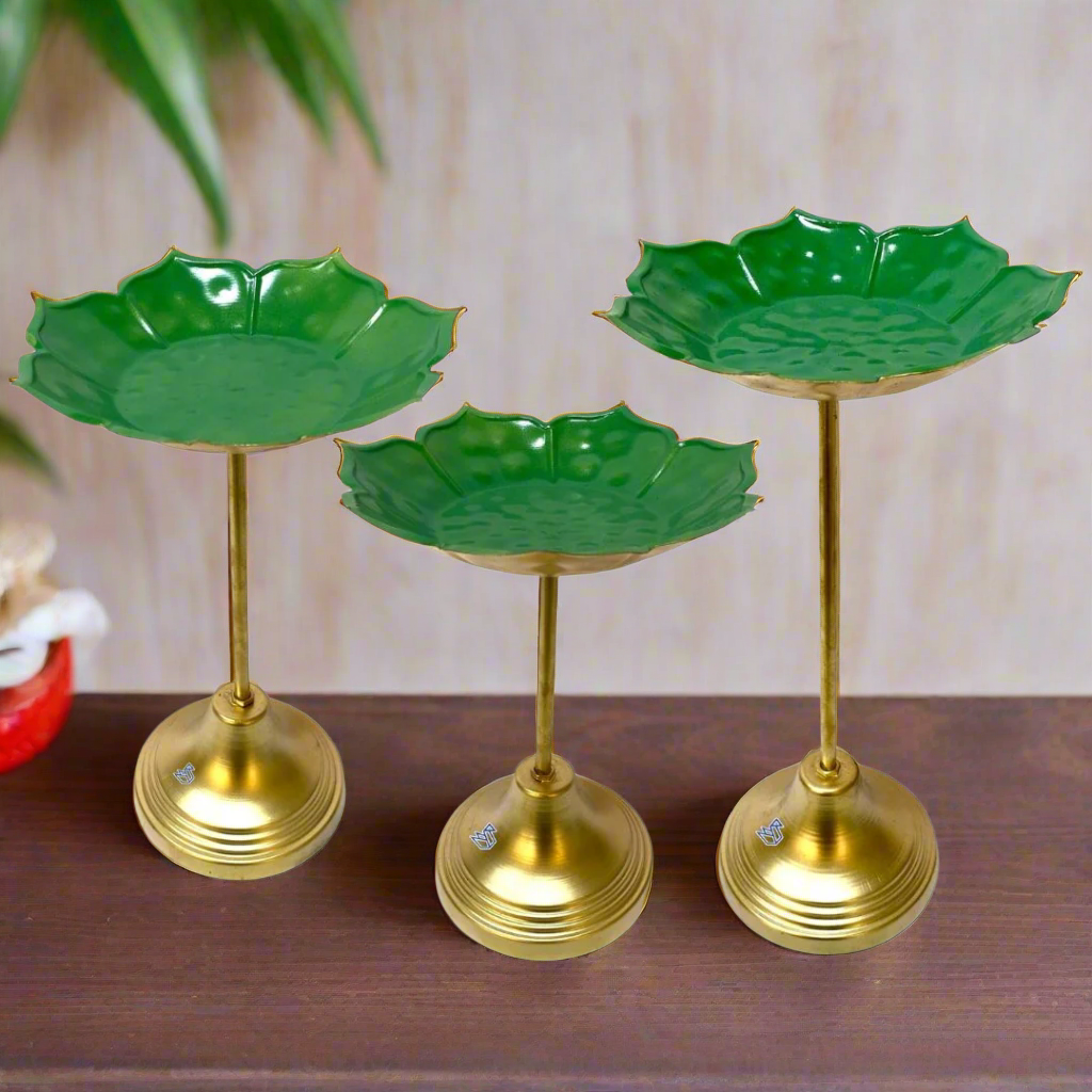 Three green leaf-shaped stands with gold bases on a white background