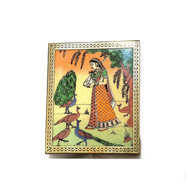 A rectangular wooden box with a colorful illustration depicting a scene with birds and a character on a tree branch.