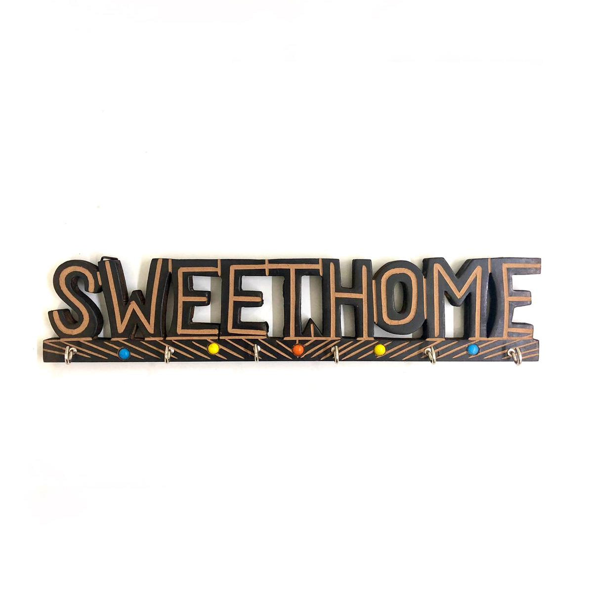 A wooden key holder with the text 'SWEET HOME' carved on it, decorated with metal accents and colorful gems.