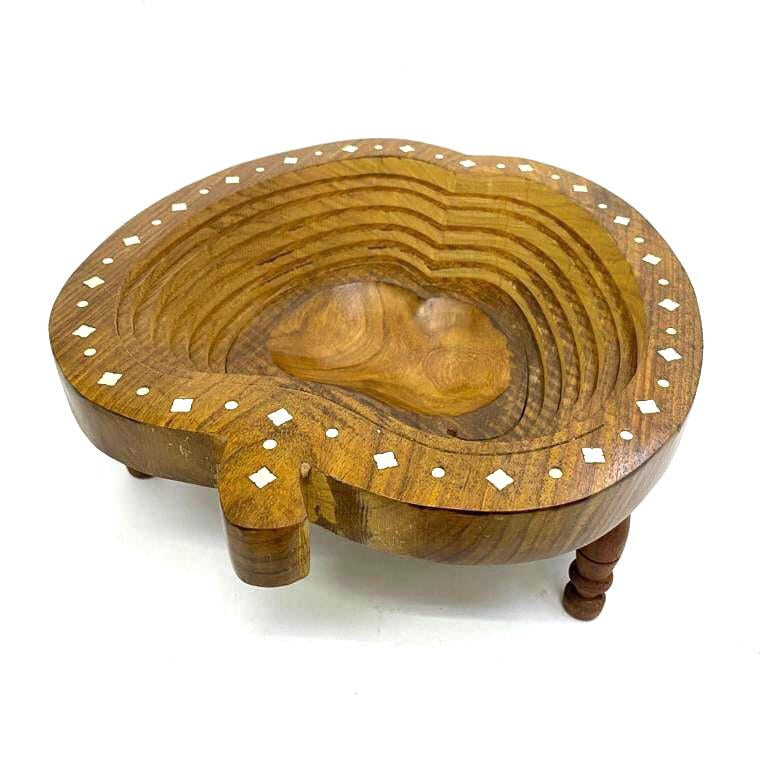 A handcrafted wooden bowl with carved concentric patterns and small white inlaid diamond accents, shown on a plain white background.