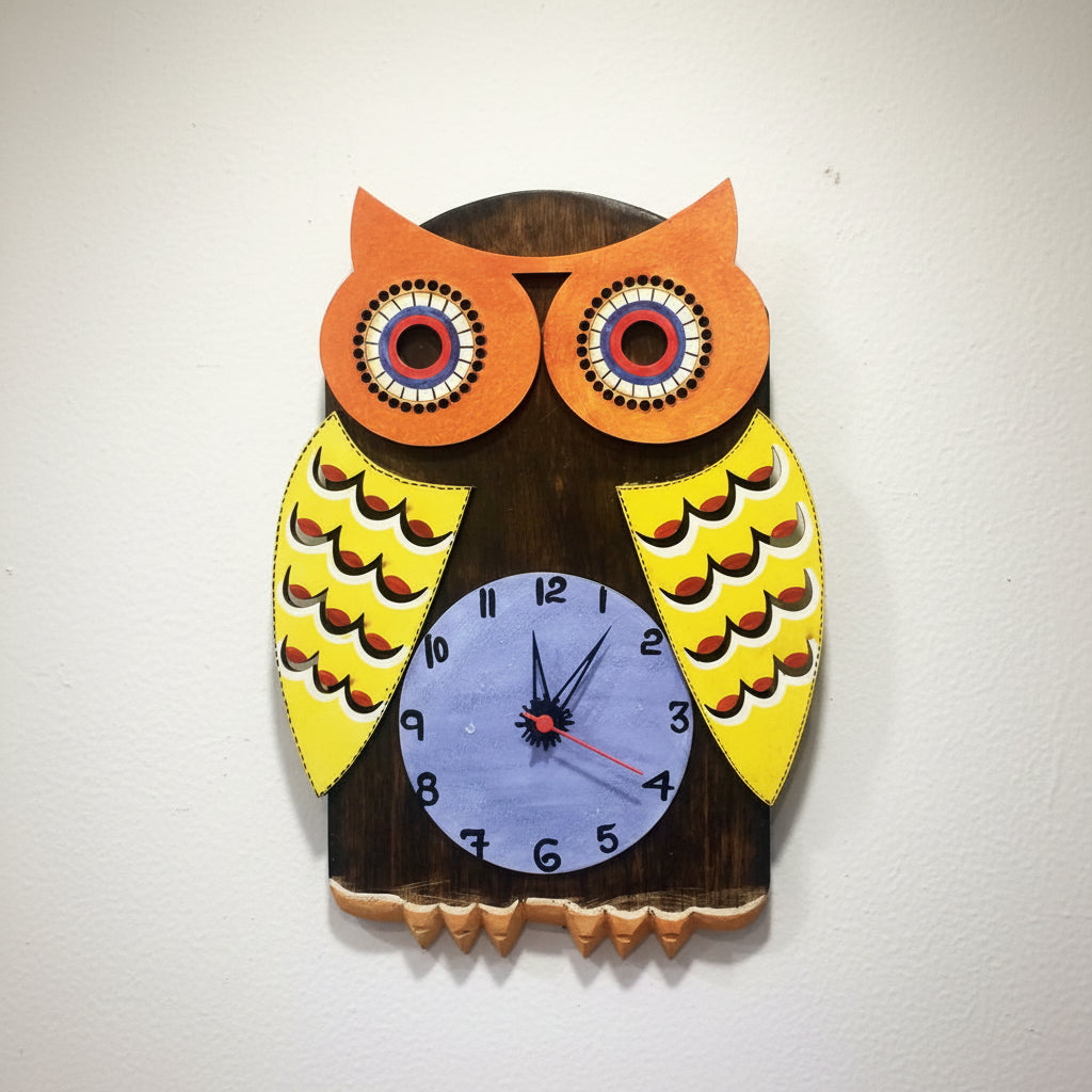 Hand painted wooden wall clock in the shape of an owl with a colorful pattern on the wings and a blue clock face with black hands and numerals.