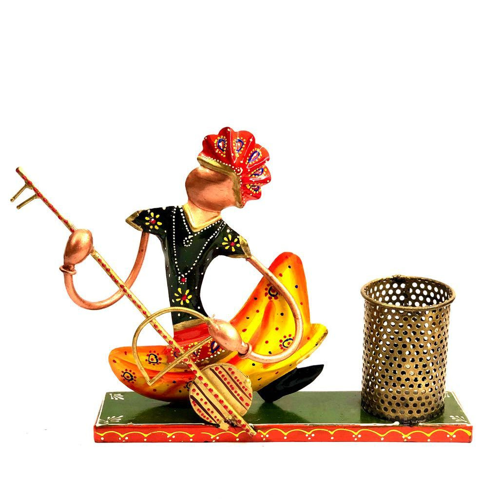 Hand painted colorful office utility pen holder featuring a musician playing a sitar, sitting next to a metal wire holder.