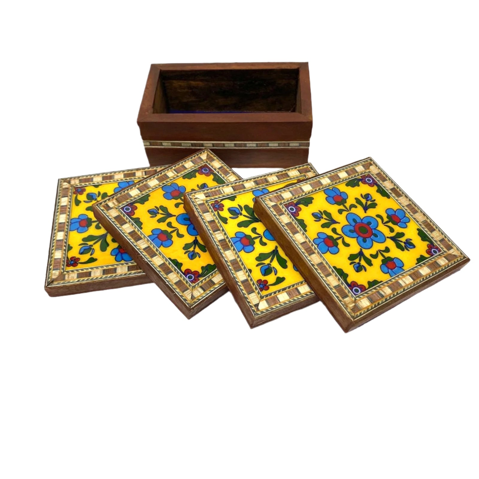 Set of four decorative coasters with floral patterns on a yellow background, placed in front of a wooden box.