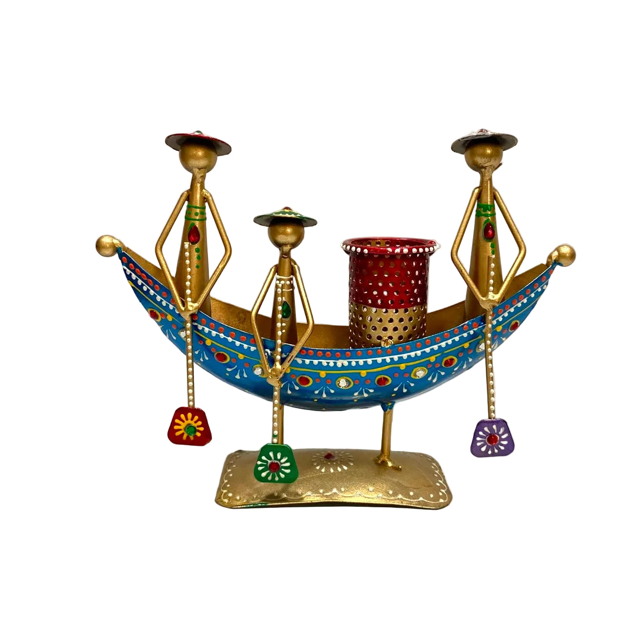 A decorative brass boat-shaped candle holder with three stylized human figures holding red and multicolored flower-shaped ornaments, and a red and gold candle cup in the center, set against a plain light background.