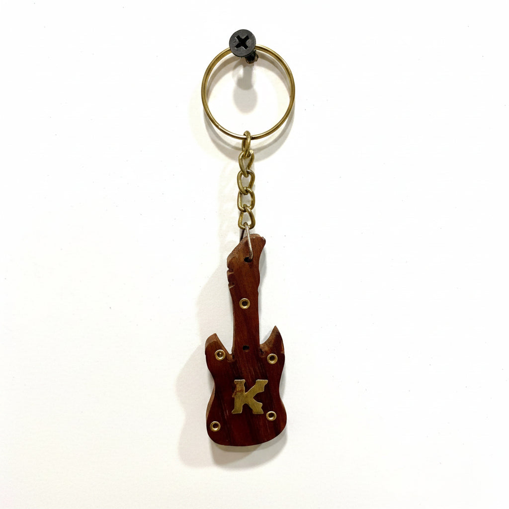 Guitar-shaped keychain with 'K' on a textured white background