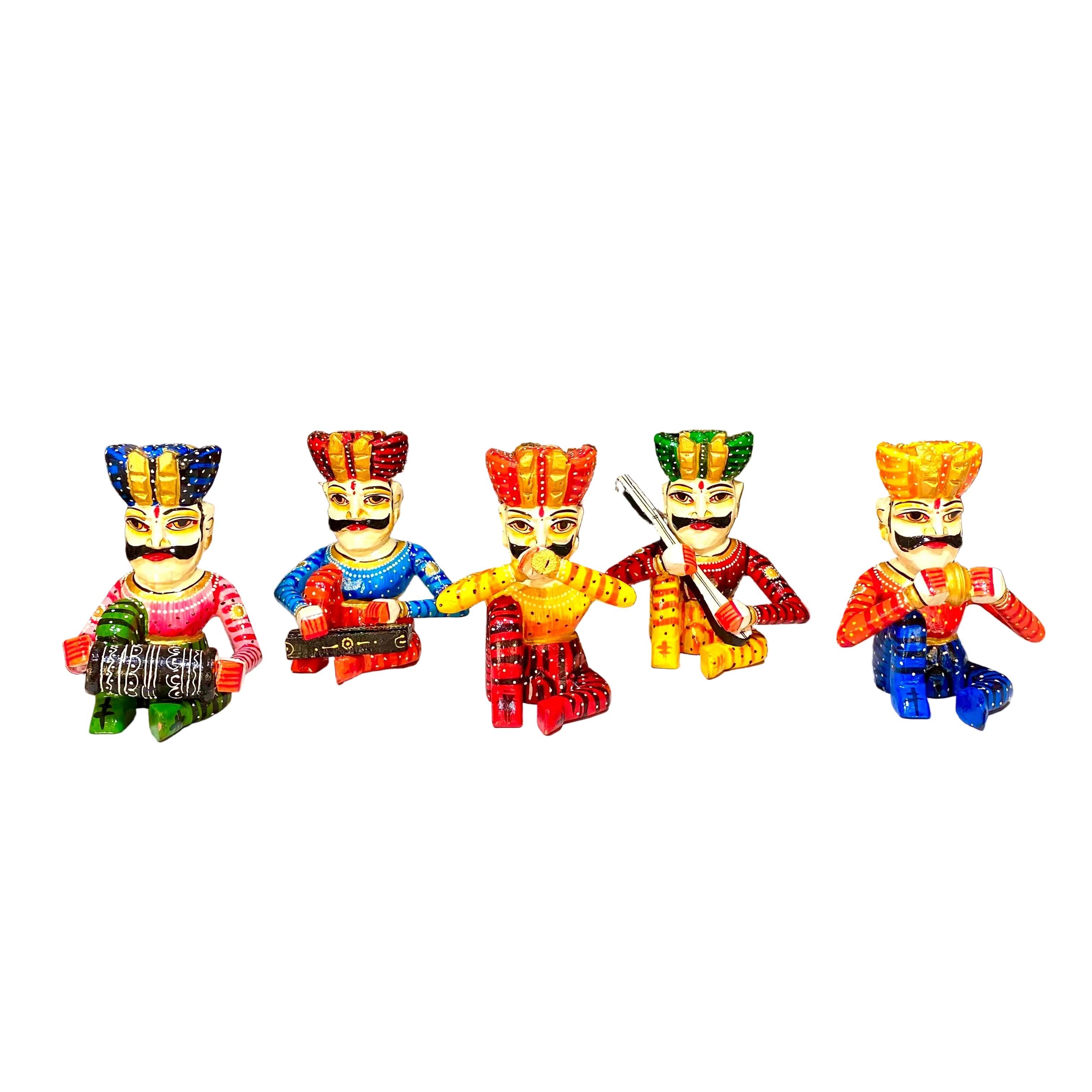 Five colorful traditional Indian toy figurines representing the five castes, displayed on a white counter in front of a glass display cabinet filled with vases and other decorative items.
