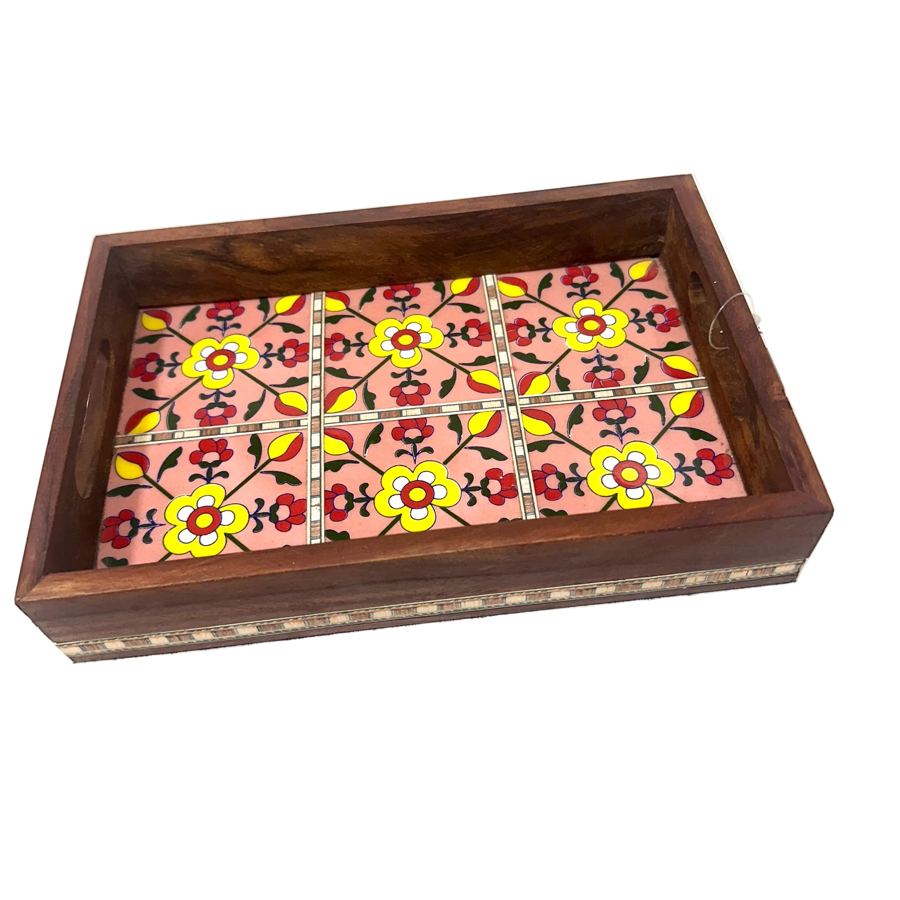 A rectangular wooden tray with a dark brown wood frame and a pink floral mosaic tile pattern inside, photographed on a white surface.