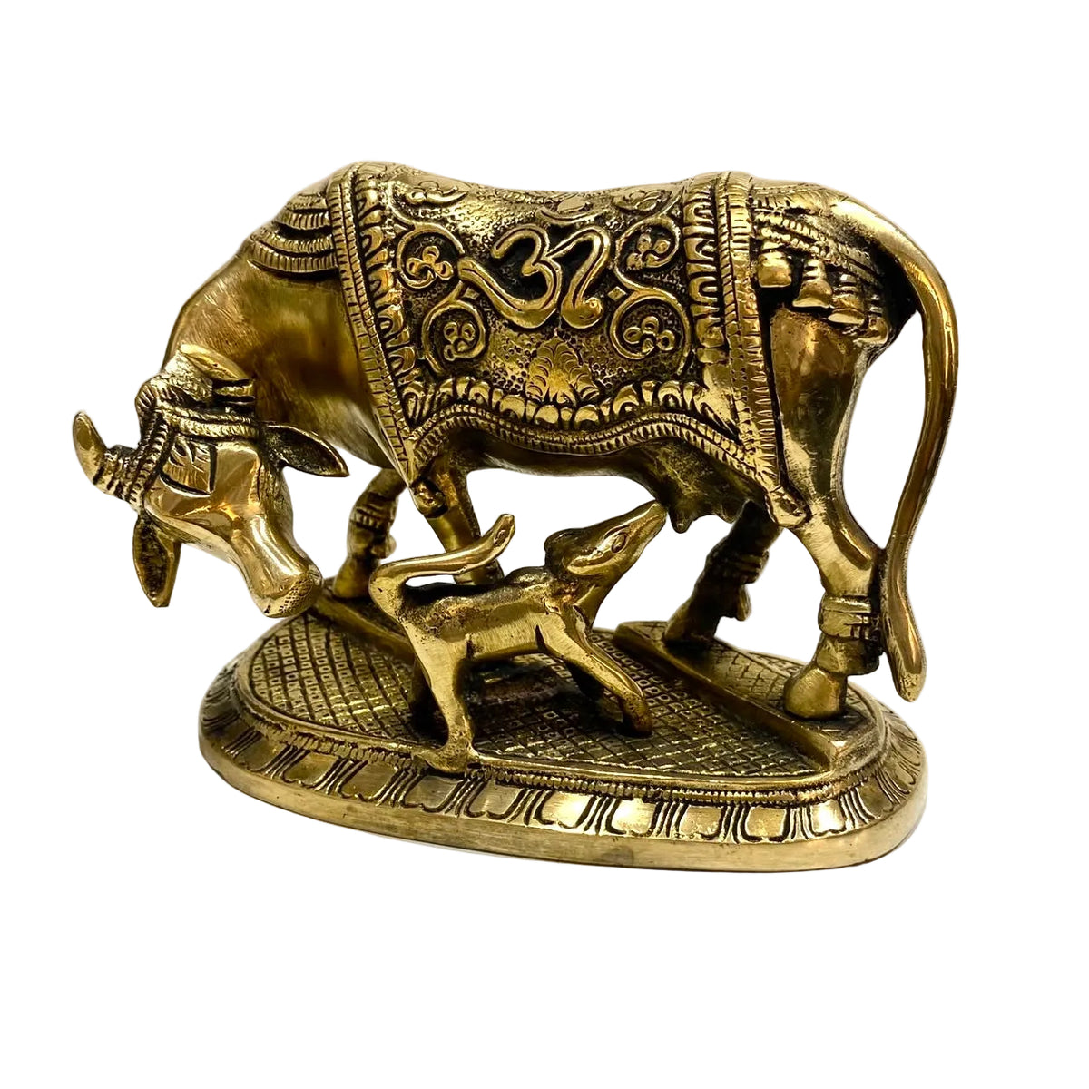 An ornate brass figurine of a cow and calf, featuring intricate engraved patterns and traditional decorative details, set against a plain light background.