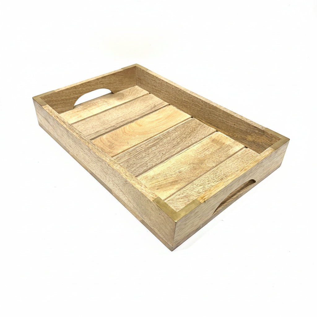 A rectangular wooden serving tray with a slatted base and integrated cutout handles, shown resting on a white table in a workshop or warehouse setting.