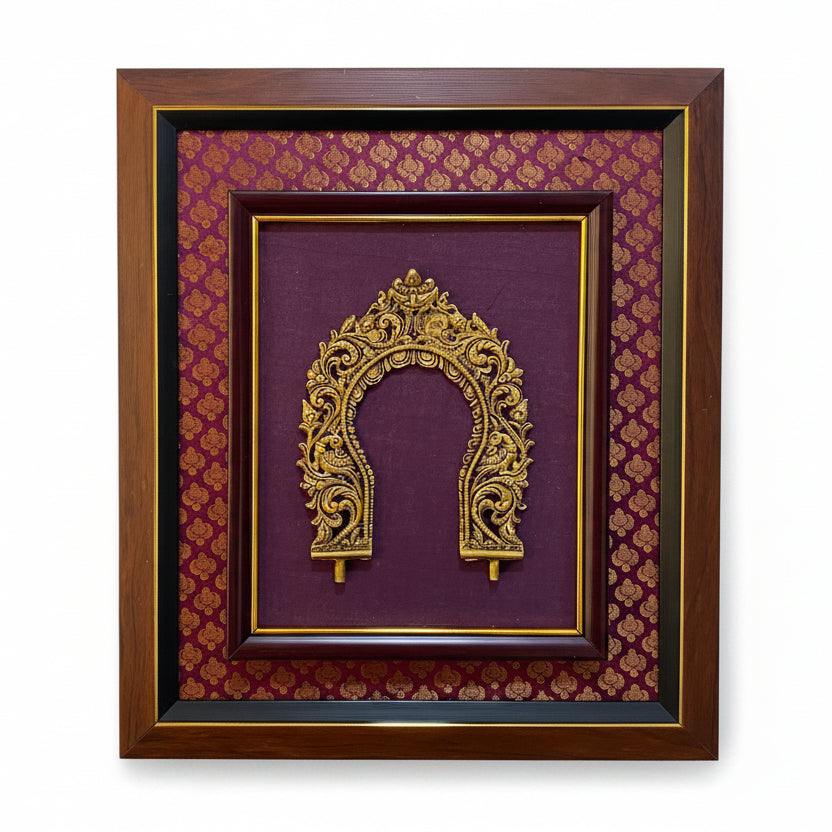 A framed decorative wall piece featuring an ornate gold arch motif mounted on a deep purple background with a repeating gold pattern, enclosed in a dark brown wooden frame against a light textured wall.