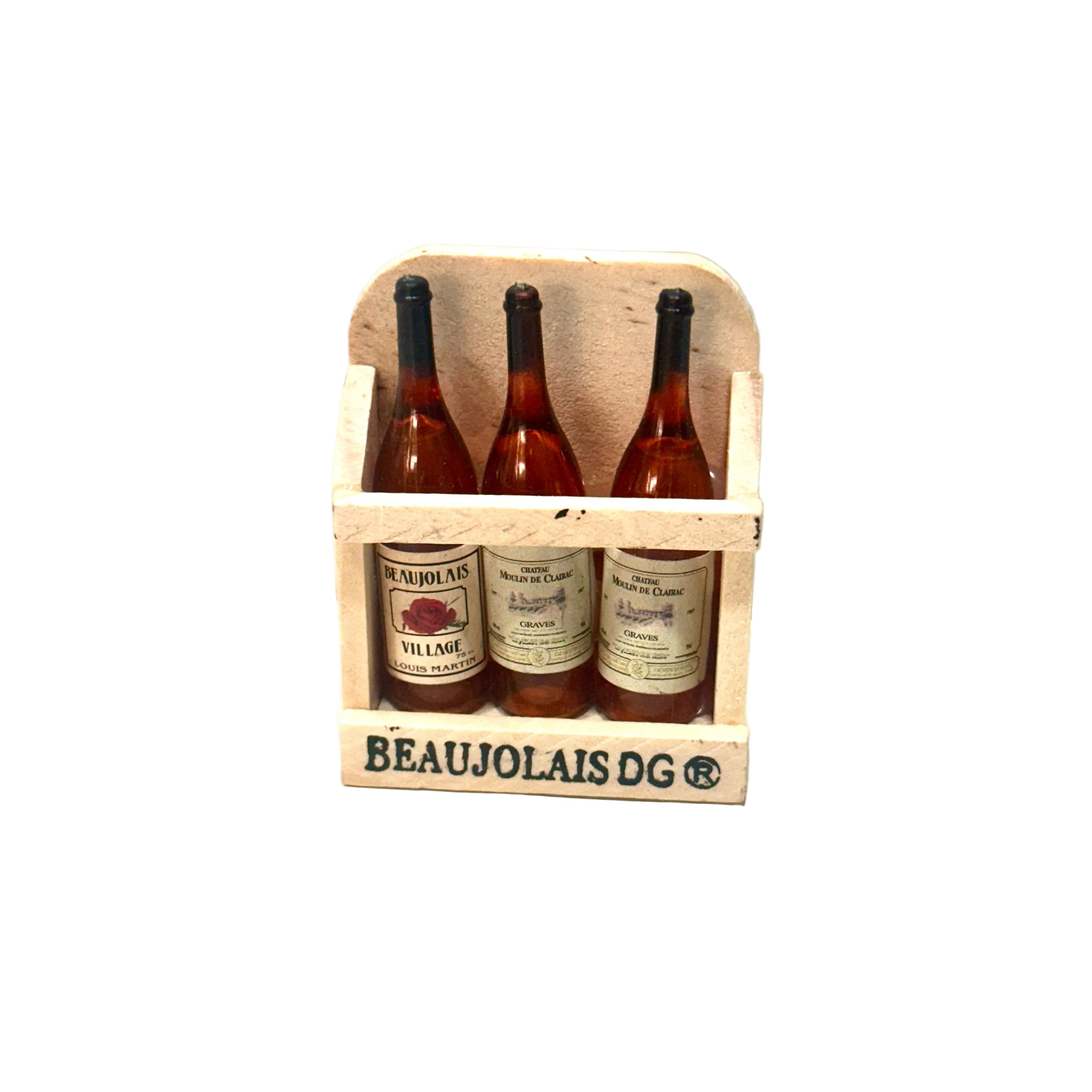 Three bottles of Beaujolais wine in a wooden crate on a white surface.