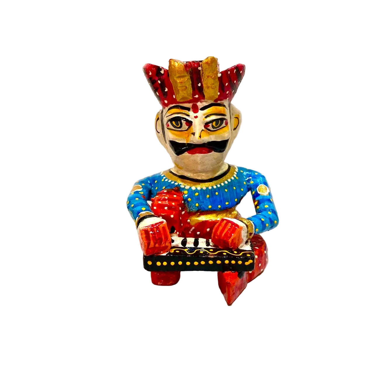 A hand-painted traditional Indian wooden figurine of a seated figure, decorated with vibrant red, blue, yellow, and black colors, set against a plain white background.