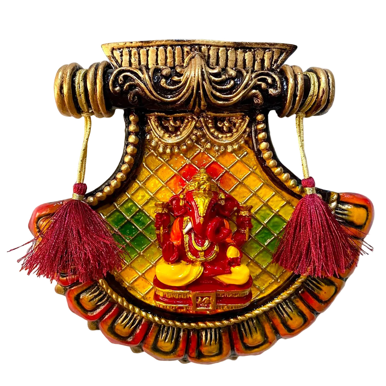 An ornate decorative wall plaque featuring a red and gold Lord Ganesha statue, mounted on a white textured wall. The plaque has a gold-colored top bar with hanging cords and two red tassels on either side.