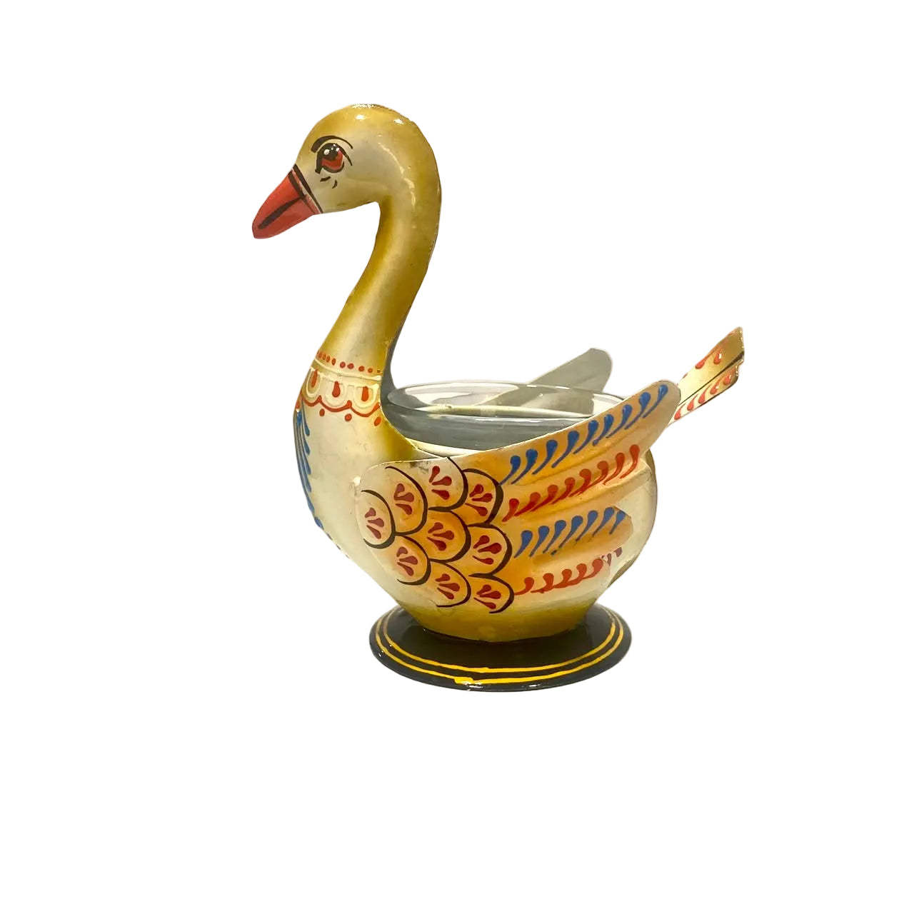 A decorative swan-shaped metal candle holder with a gold-toned body, red and blue painted patterns, and an orange beak, set on a white surface against a plain light background.