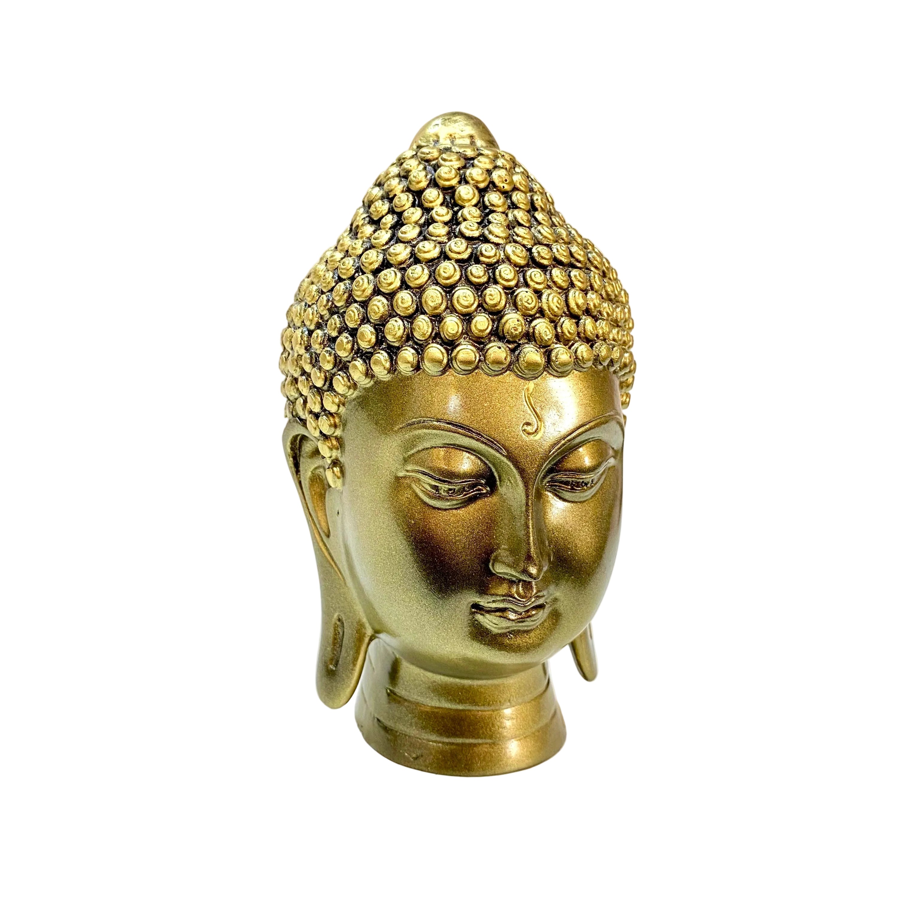 Bronze Buddha head sculpture on a white surface with a blurred background