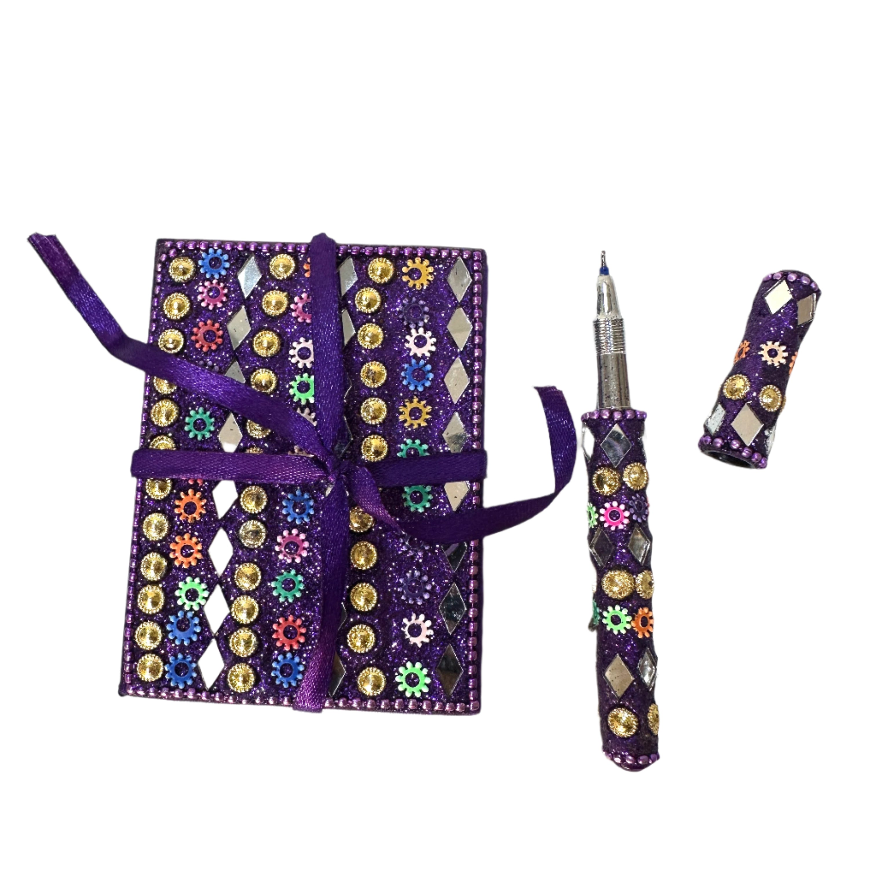 Decorative notebook with embellishments and a matching pen on a textured white surface