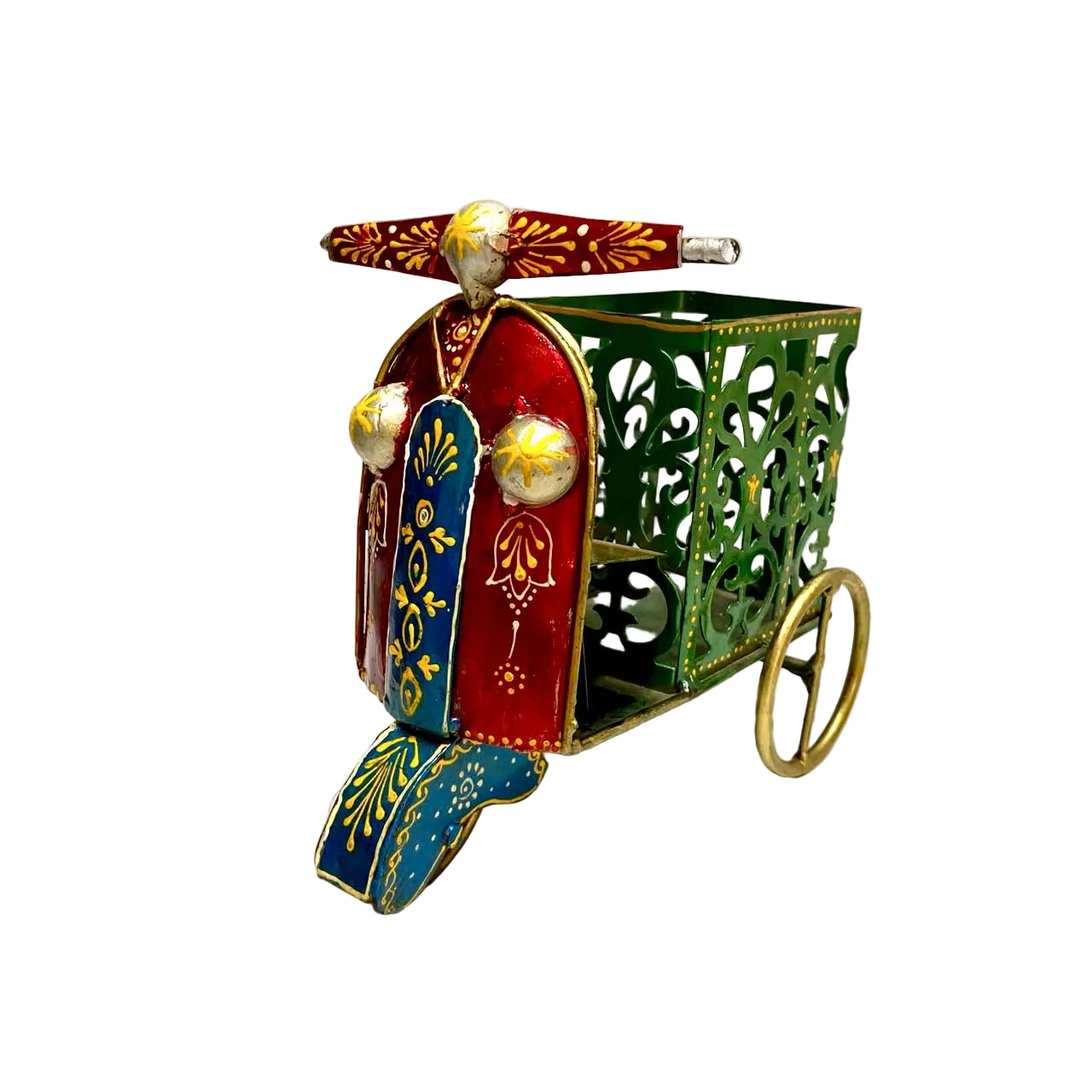 A decorative vintage-style miniature carriage or palanquin ornament with ornate cutout green sides, red front panels, blue flap, gold accents, and brass wheels, photographed on a white surface against a white wall.